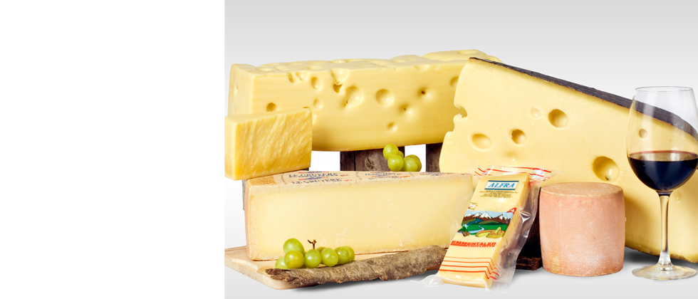 Tagli di emmentaler e gruyer con bicchiere di vino rosso